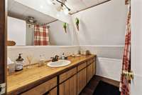 Main level full bathroom with a tub/shower combo and lots of cabinets and drawers for storage.