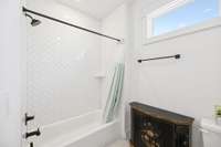 Bright tub-shower combo with stylish diagonal subway tile.