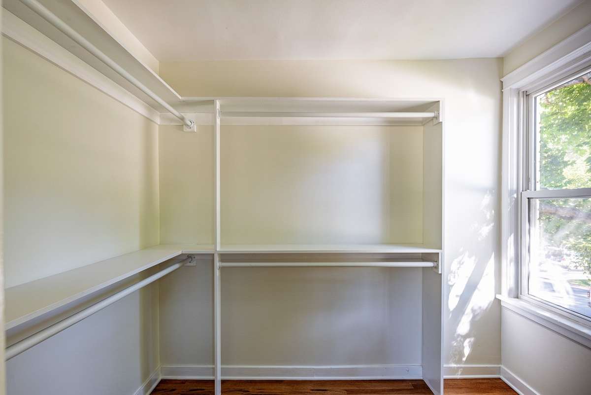 The walk in closet it set up with plenty of hanging space and space for folded clothes, bags, etc.
