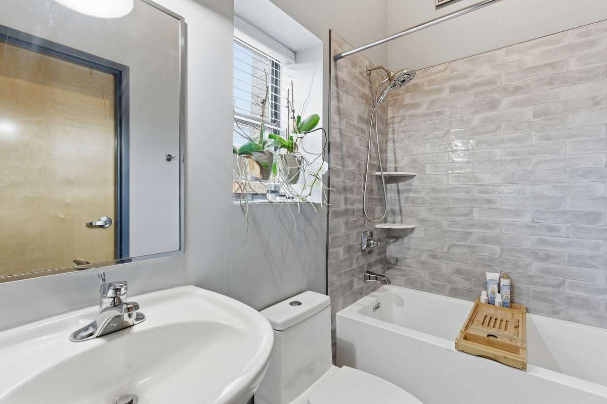 Bathroom features a newly renovated 22in deep tub with serene subway tile