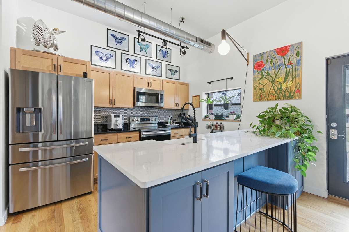 Kitchen is bright + sunny with a beautiful quartz island that offers storage below