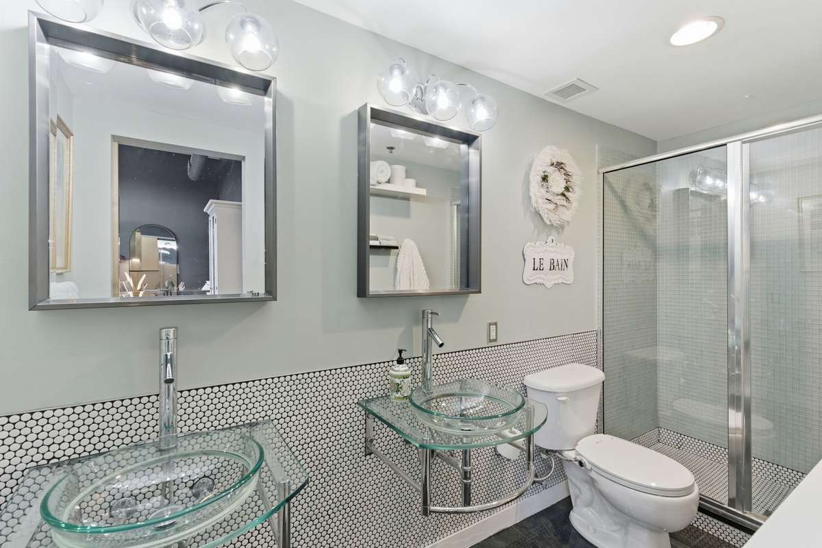 Double glass vanities, tiled shower + glass door