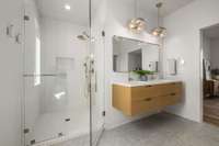 Floating vanity with designer fixtures, beautiful heated porcelain tile floors, and floor-to-ceiling tile in the shower