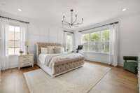 Light filled primary bedroom is a showstopper with its custom accent wall.