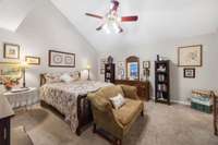 The expansive primary suite features vaulted ceilings with lots of windows, offering lots of gorgeous, natural light.