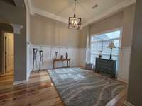 Formal dining room with beautiful tall ceilings and wood work.