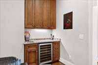 a wet bar with a wine refrigerator, perfect for entertaining