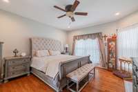 We continue to the primary bedroom of the home which is also on the main floor.  When you walk into this bedroom, to the right you will see a door that goes out to the screened in back porch. This is such a wecoming room!