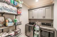 Large main level laundry room located next to kitchen pantry and primary suite.