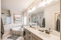 The primary en-suite bath features a spacious walk-in shower and a relaxing soaking tub, creating a spa-like retreat