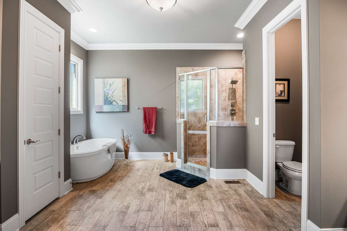 Your private sanctuary awaits in the sprawling 14'x22' primary ensuite. Here, a luxurious soaking tub beckons for indulgent moments, perfectly complemented by the oversized rainfall shower. Dual vanities ensure a serene separate start of the day.
