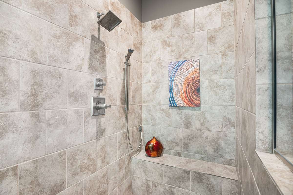 Enjoy the striking design of the oversized tiled rainfall shower, seamlessly integrated into the spa-inspired aesthetic.