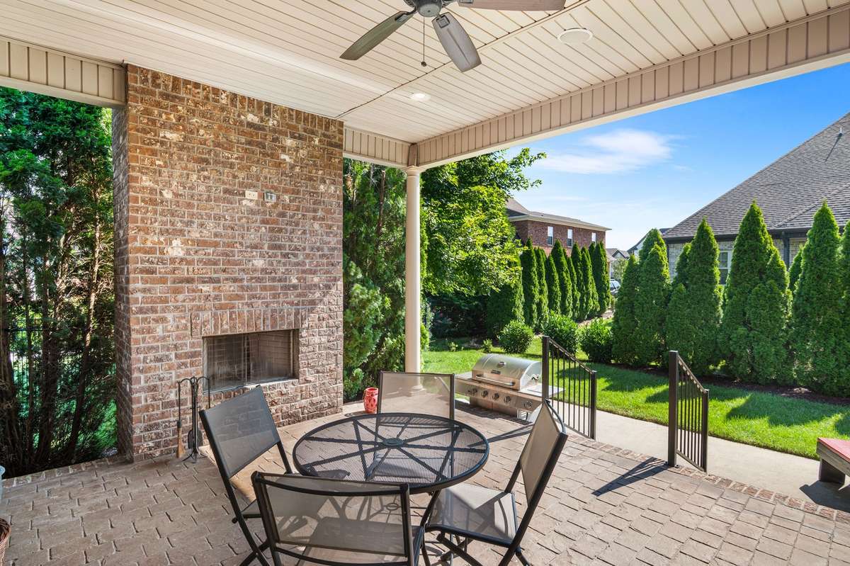 Covered back porch expands the entertainment ambiance with lush privacy, cozy wood burning fireplace with custom crafted stamped patio.