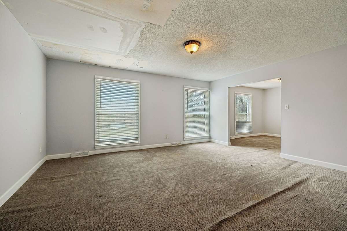 Main living room with formal dining room to the right. Roof has been repaired.
