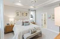 Spacious primary suite upstairs with tray ceiling & private bathroom. King size furnishings pictured here.