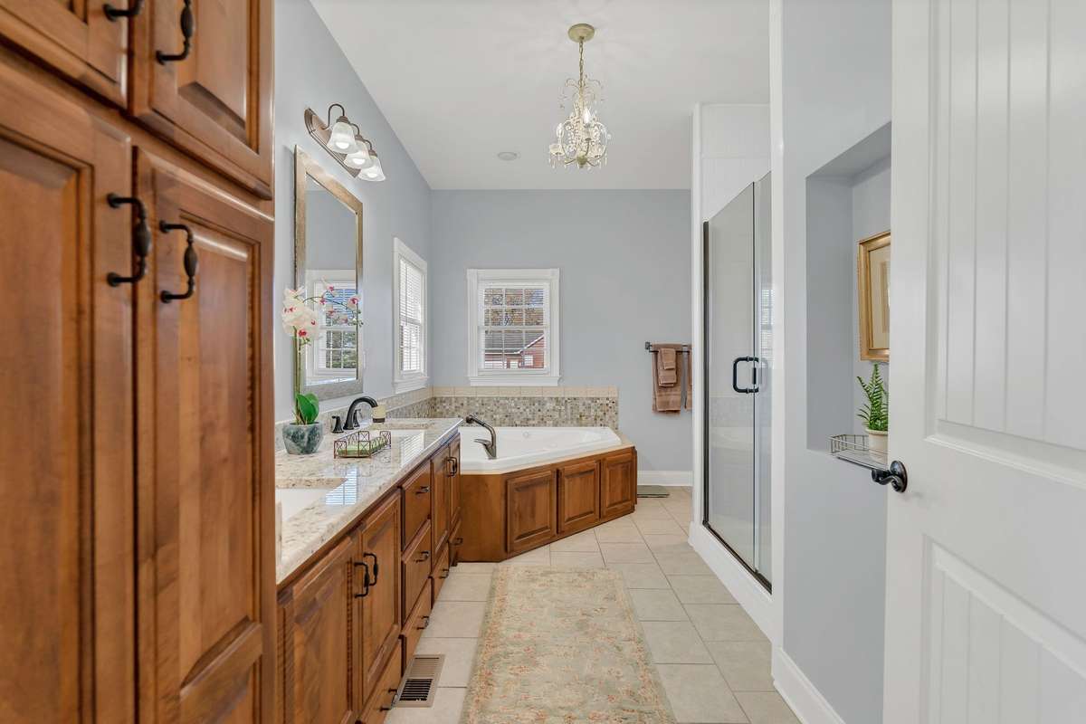 The Primary Bath has custom cabinetry, designer alcove, double sinks, jacuzzi tub, new tiled shower and walk-in closet.