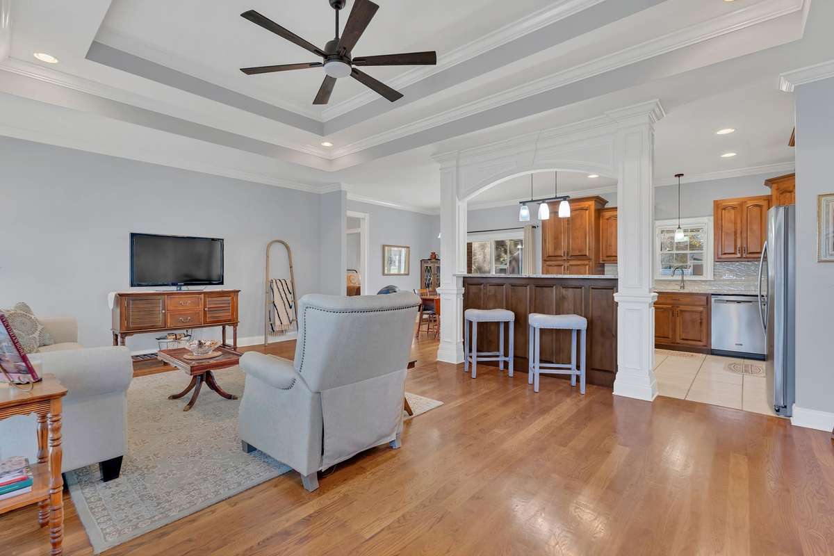 The Great Room opens to the dining room and kitchen. A heavy crown molding archway separates the kitchen from the Great Room.