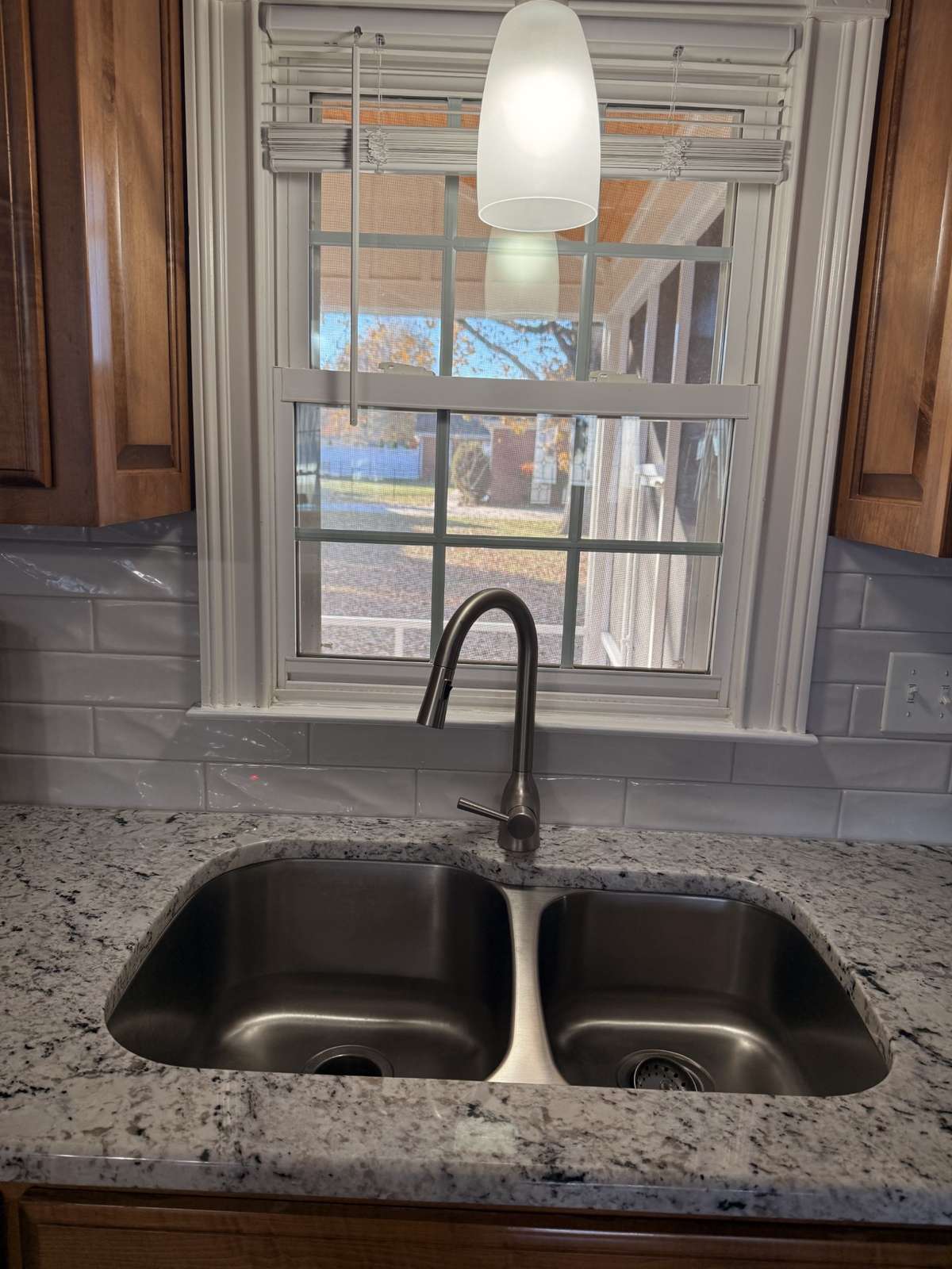 A new stainless sink has a window overlooking the back yard.