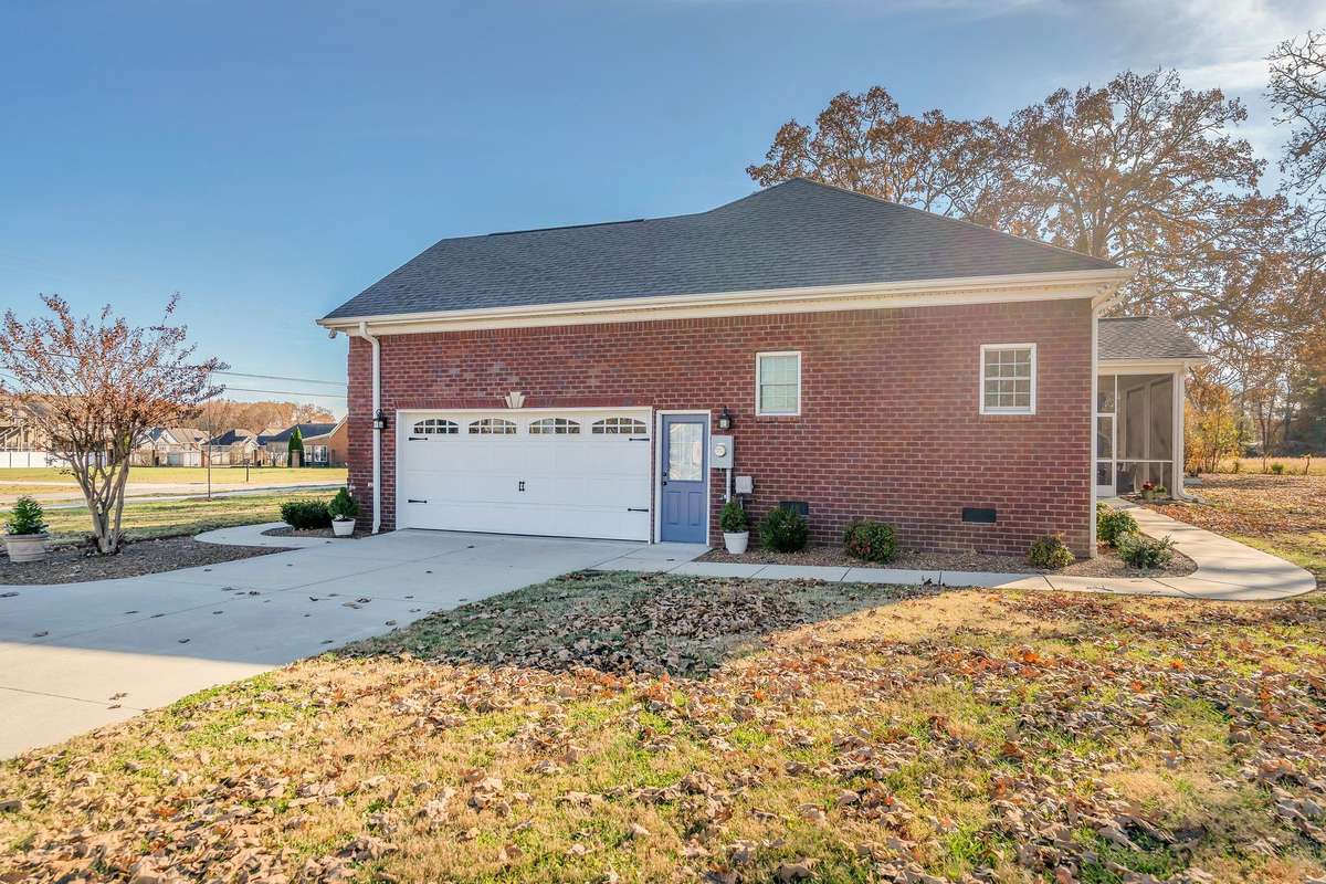 A concrete drive with turnaround leads to the double garage. A new sidewalk leads to the  screened back patio.