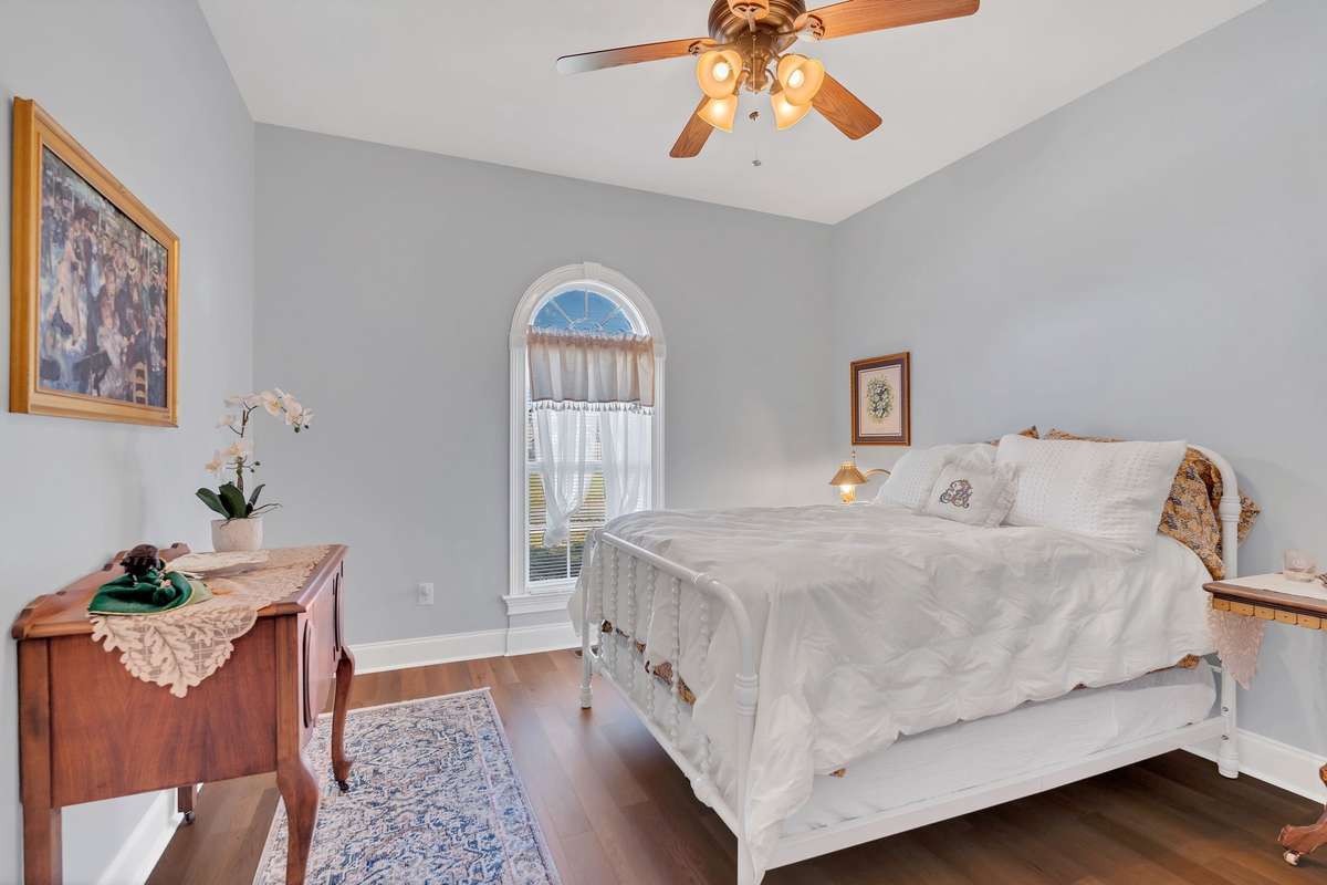 The second bedroom has a window overlooking the front yard. The ceiling fan and flooring are new.
