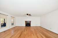 Main floor- Living Room- wood flooring, ceiling fan, gas log fireplace