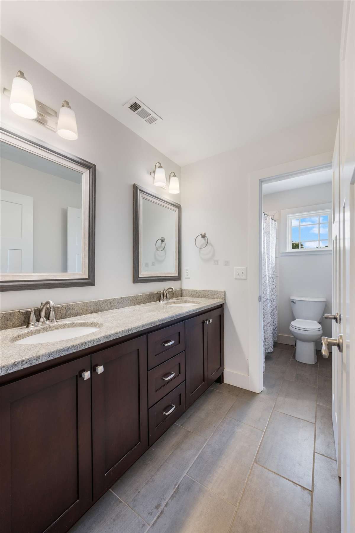 Upstairs bathroom with double vanities and a tub/shower combo
