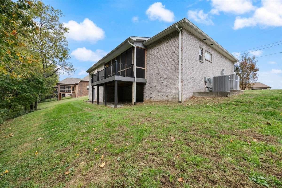 The back of the house showing the screened in deck with a open balcony