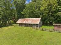 The property also features a charming four-stall barn with a tack room, ideal for equestrian pursuits or hobby farming.