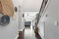 Step down the hall toward the main living area or through the arched hallway toward the private office.