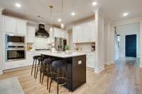 Gourmet kitchen with all the extras.  Wood hood vent, gas cooktop, stainless steel appliances, island, stainless steel appliances, and backsplash tile to the ceiling!