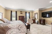 Thick crown molding and recessed lighting in the primary bedroom