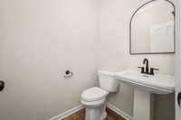The half bath features a new pedestal sink, faucet and water closet.