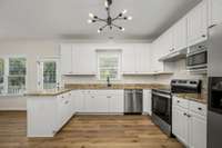 The open kitchen features granite counters, new appliances and also looks onto the backyard- perfect for watching the children play.