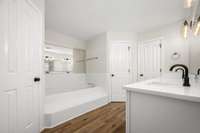 The primary bath features more LVP flooring, 2 walk-in closets and a jetted tub.