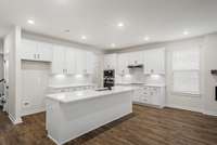 Kitchen includes beautiful upgrades like quartz countertops, classic tile backsplash, undercabinet lighting, and soft-close doors/drawers!