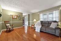 A sectional would fit nicely on the L-shaped wall where the rocking chair is for even more seating.