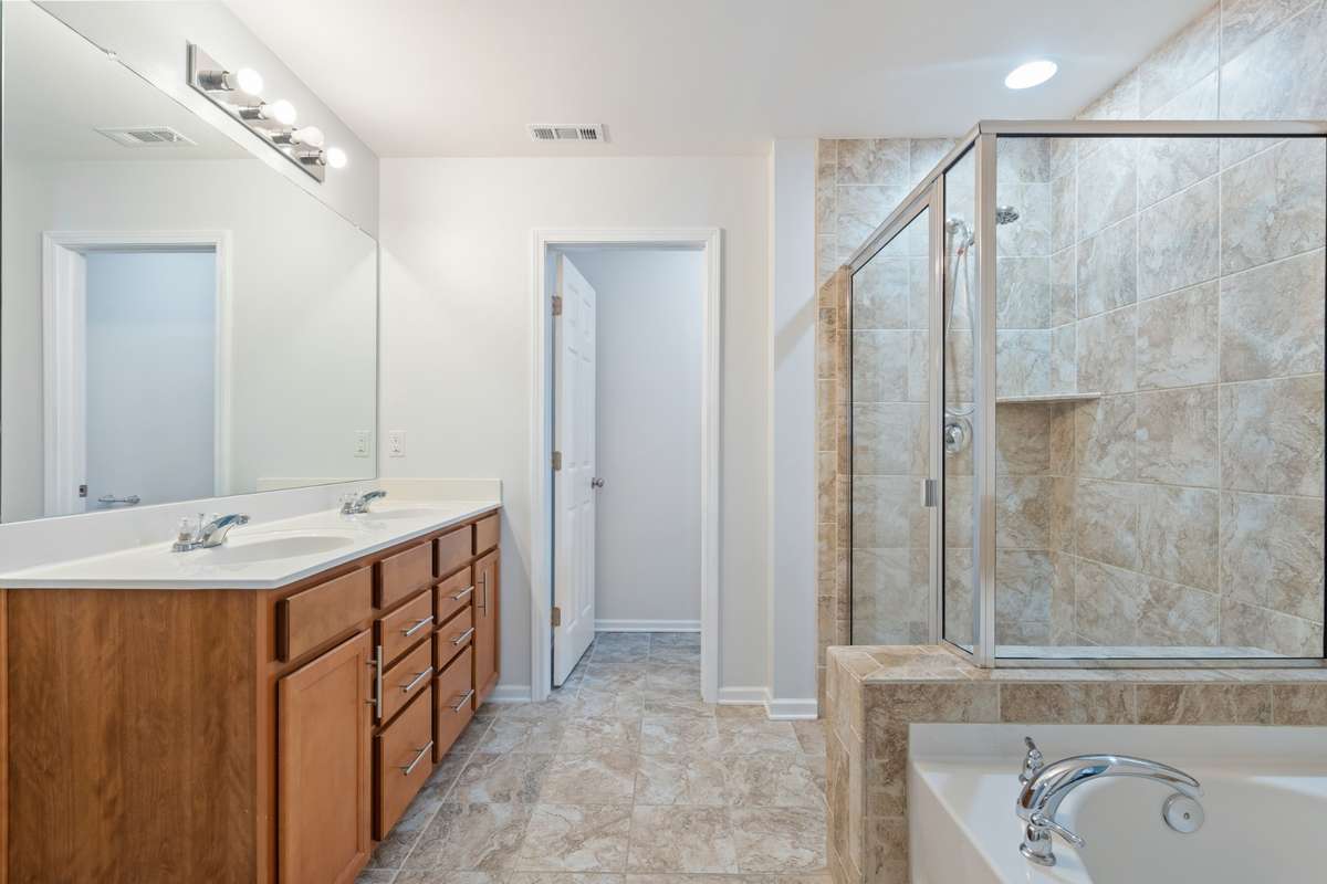Primary ensuite bathroom with double vanities and massive closet. New updated sink faucets coming soon.