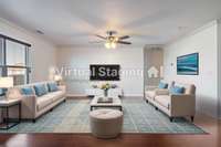 Virtually staged living room that is open to the kitchen.  Door on the right leads to a ground floor guest suite with a large walk in closet.
