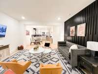 9 ft ceilings with open layout:  living room with accent wall, dining area and 3 bar stool counter in the quartz countertop kiichen.
