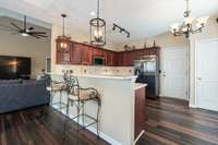 A renovated chef's kitchen features fresh SS appliances, Quartz countertops, tile backplash, hardware/fixtures + accent lighting.