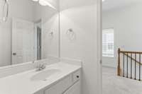 Upstairs bathroom off landing. Bathroom is between bedrooms with access from each bedroom. Features separate sink and tub/toilet areas.