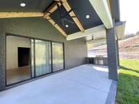 Actual Home — Slider Doors in Gameroom Open to Outdoor Covered Porch with Grilling Area and Vaulted Ceiling w/ Wood Beams — Construction Progress Photo