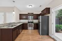 Cook's dream kitchen with plenty of cabinet space and spacious countertops in granite with tiled backsplash.