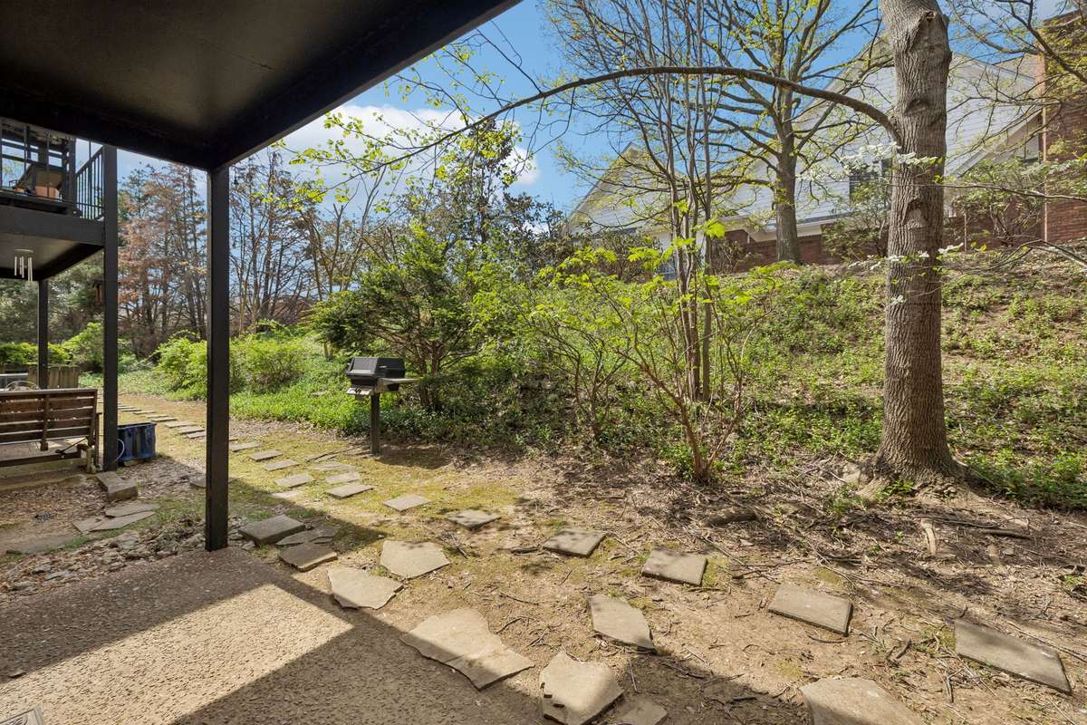 This unit has a patio off the rear of the home with a little wooded area .