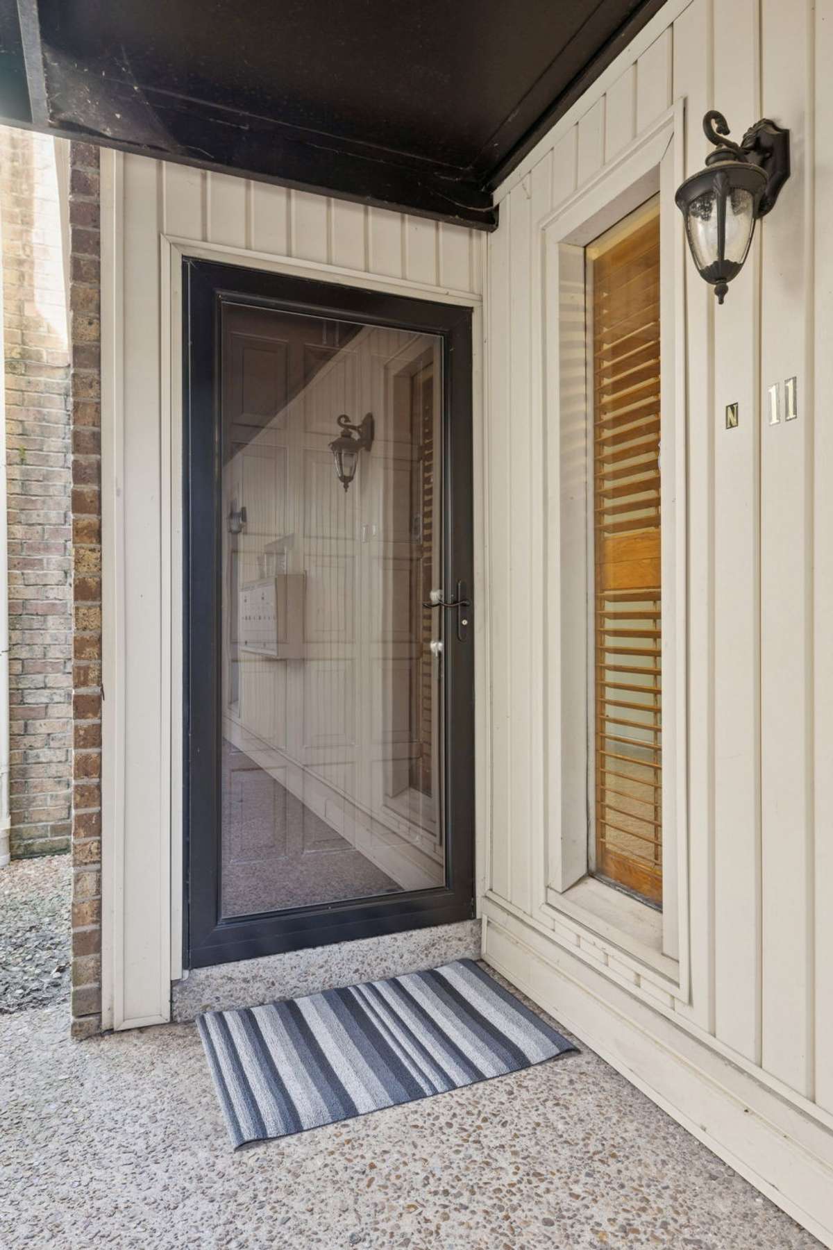 The entrance for Unit #11 in the "N" building, located on the ground floor! There is a window to the right with a plantation blind!