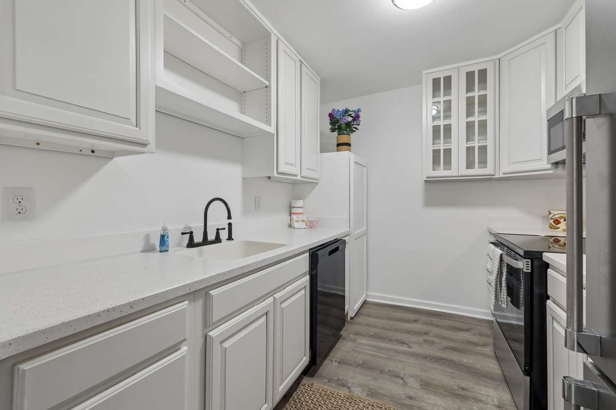 The newly updated/remodeled Kitchen! There are a couple of pull out drawers, some cabinet storage with glass fronts, a new faucet for the sink, new counters, luxury vinyl plank flooring and new appliances (refrigerator near-new)!