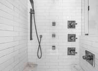 Indulge in the ultimate shower experience with a rainfall showerhead, multiple body sprays, and sleek tile surround.