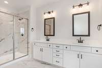 Picture is of the Madison Americana built on another lot. Gorgeous primary bathroom with double vanities, tiled shower and quartz countertops. Soft close drawers and cupboards even in the bathroom!