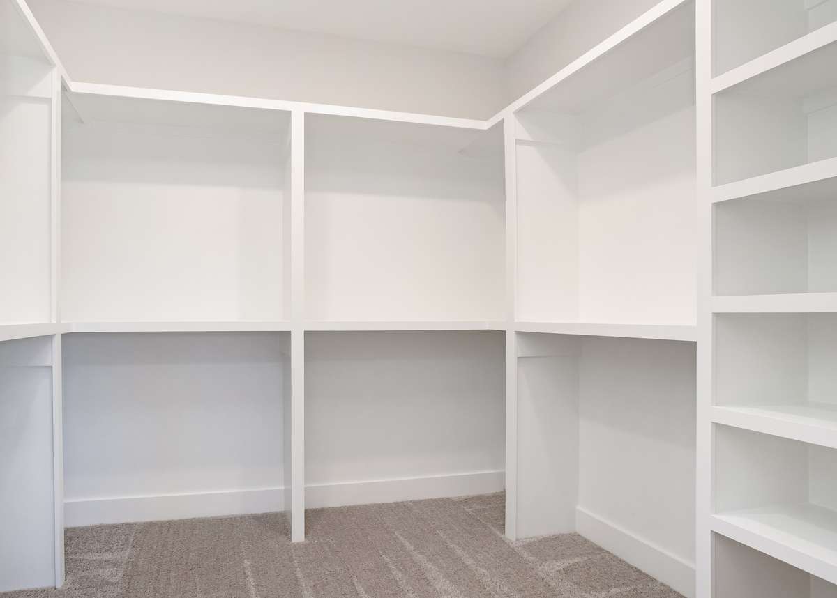 Picture is of the Madison Americana built on another lot. Primary closet prior to rods being hung.