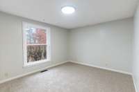 Bedroom 2 offers a bright and welcoming feel with its large window overlooking the mature landscaping outside along with fresh paint and brand-new plush carpet